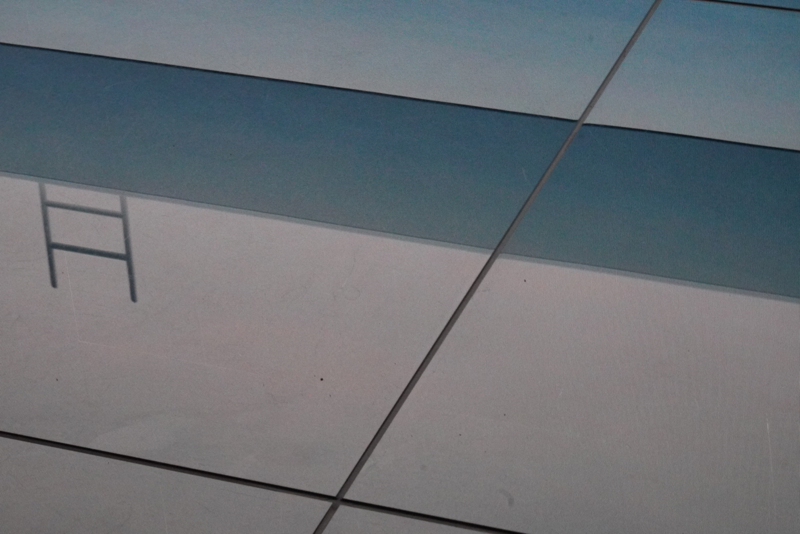 Reflection of a ladder on a glass surface.
