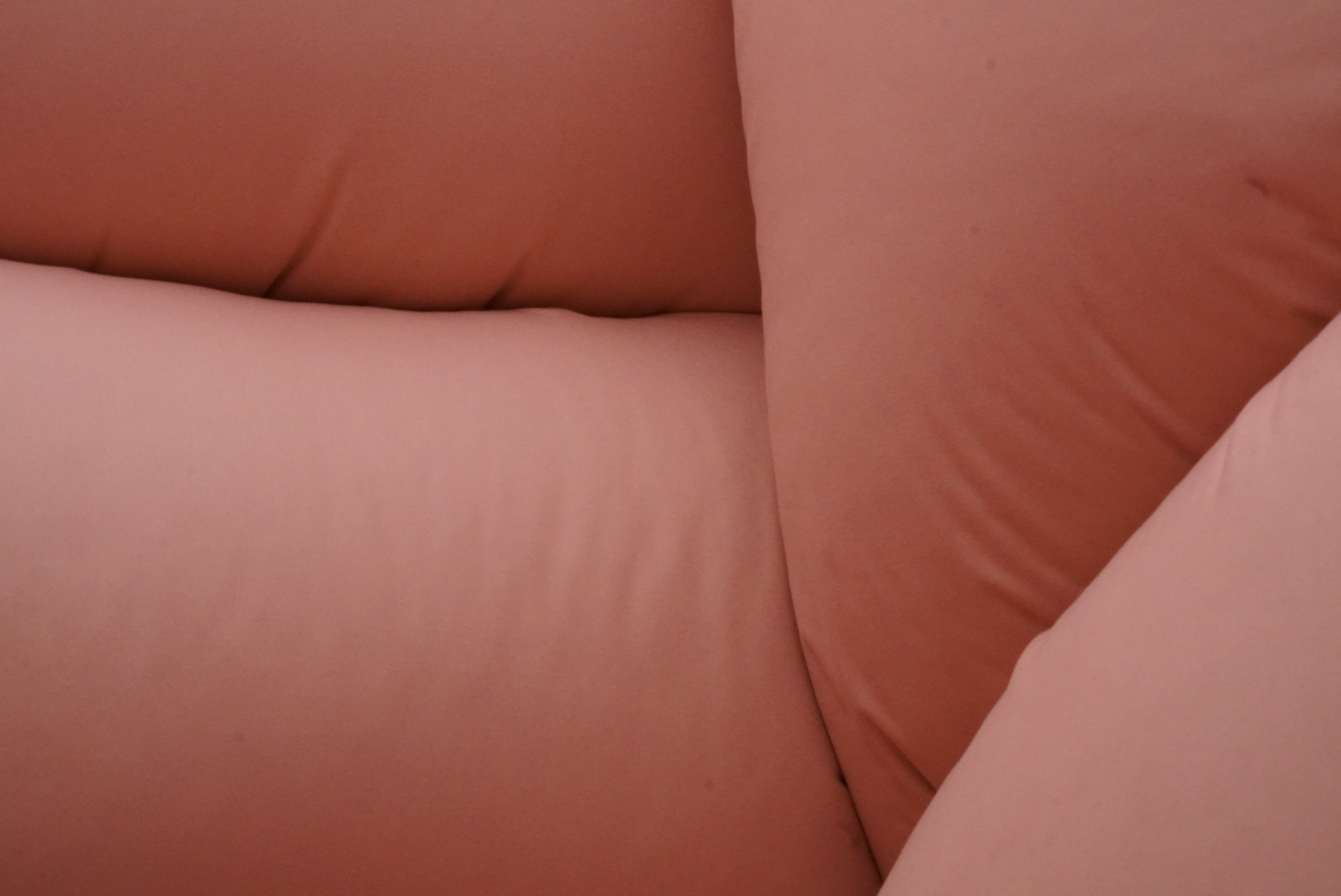 Close-up of pink cushions pressed tightly onto one another.